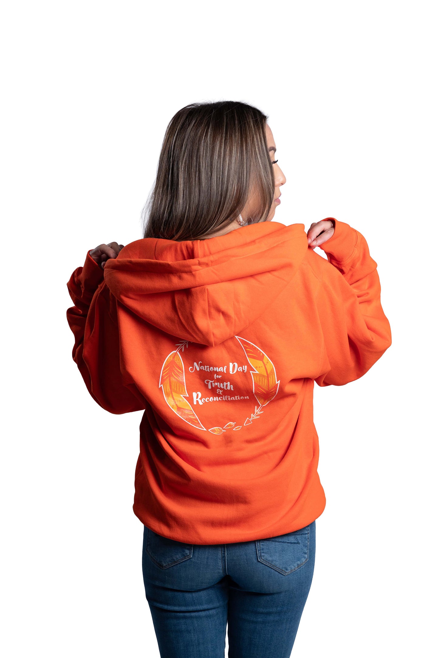 Person wearing an orange hoodie with a design on the back, standing against a white background