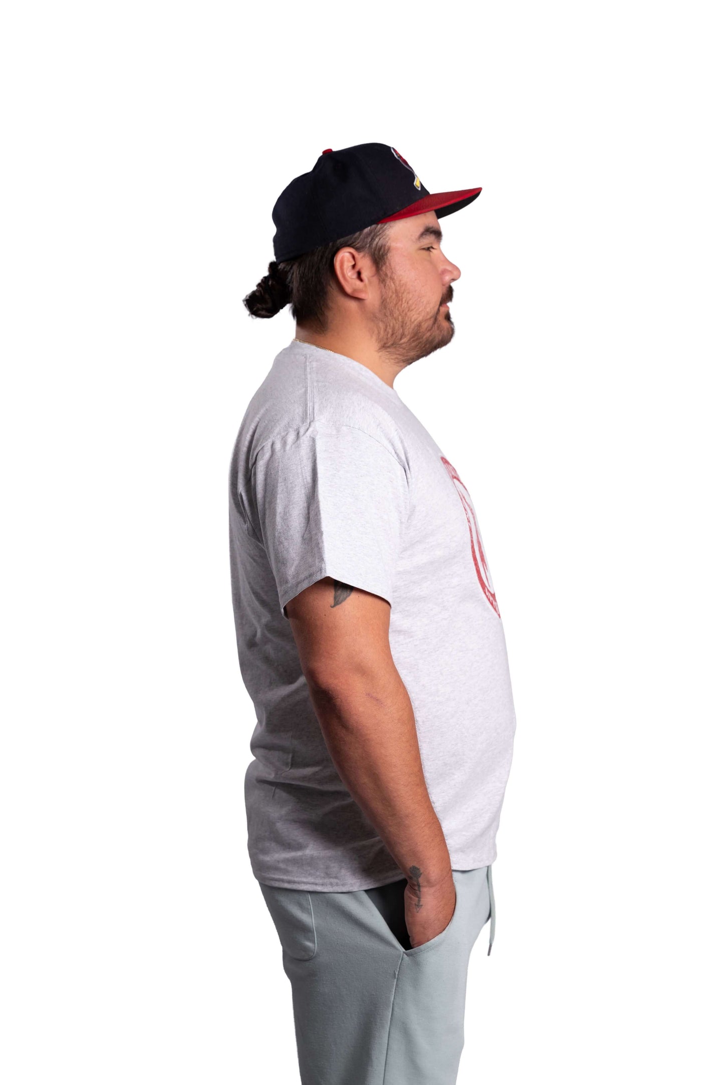 Man wearing a white t-shirt and gray pants on a white background