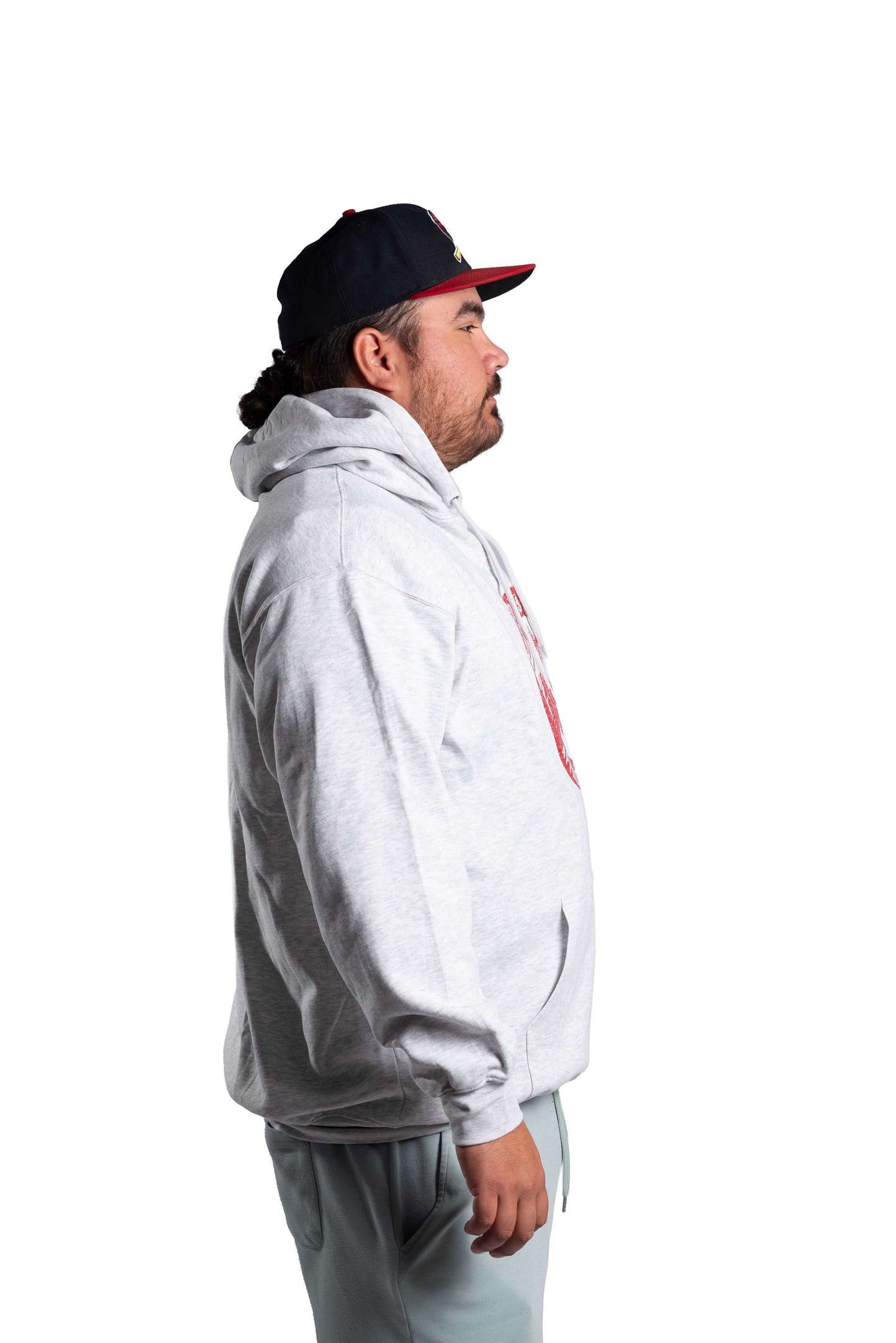 Person wearing a white hoodie and black cap on a white background
