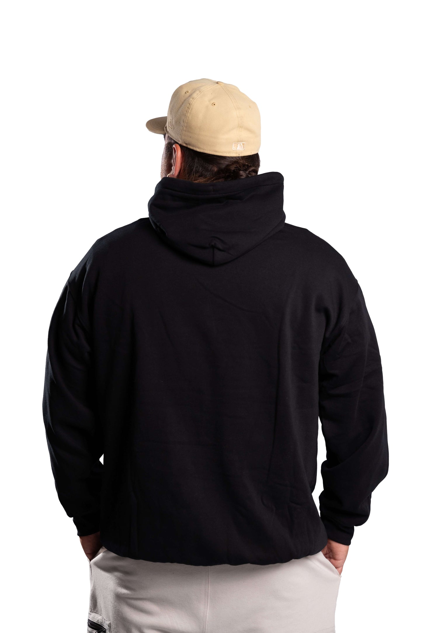 Person wearing a black hoodie and beige cap from behind on a white background