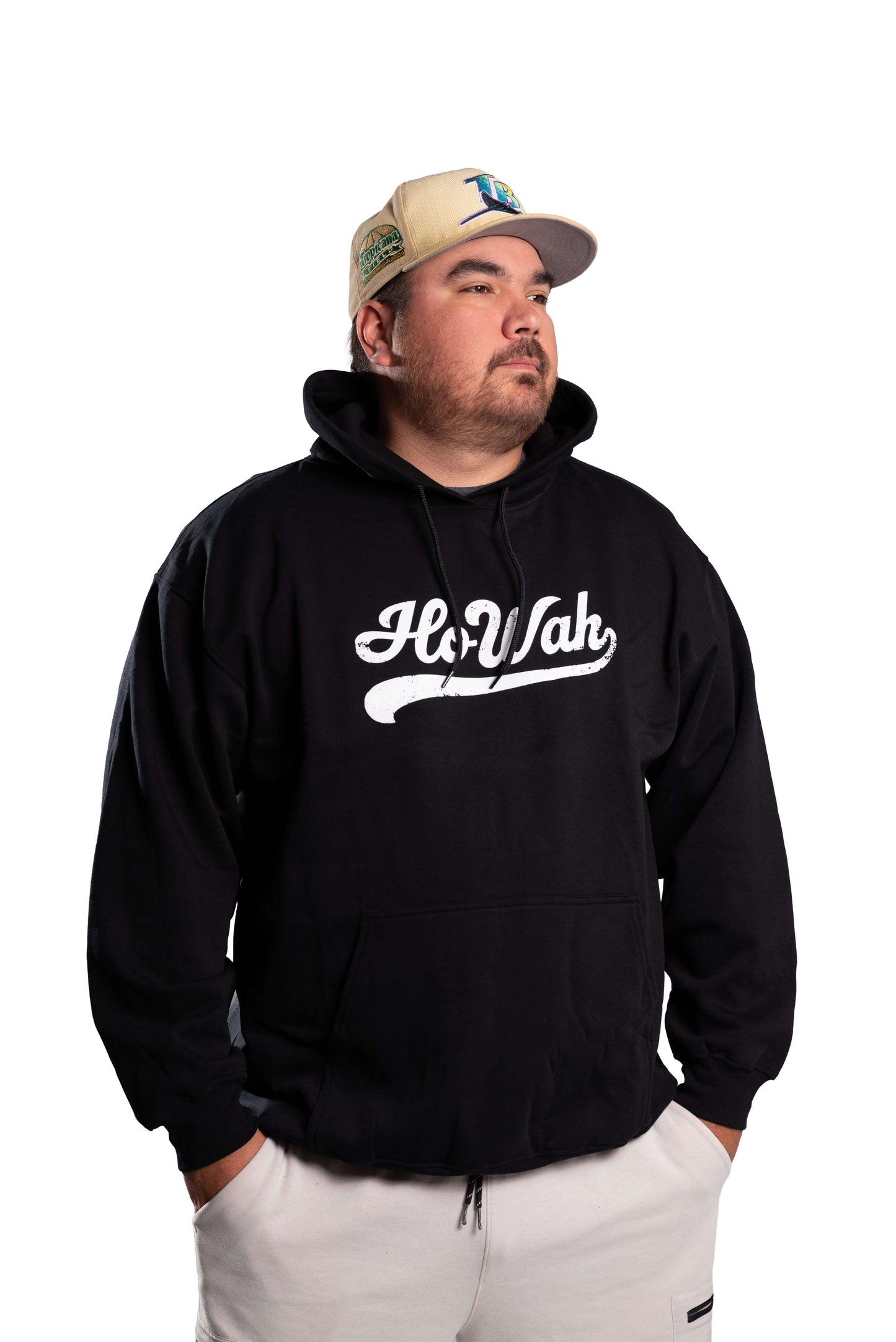 Person wearing a black hoodie with 'Ho Wah' logo and a cap on a white background