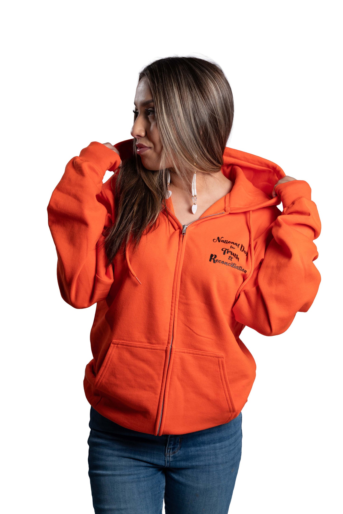 Woman wearing an orange hoodie with text on a background