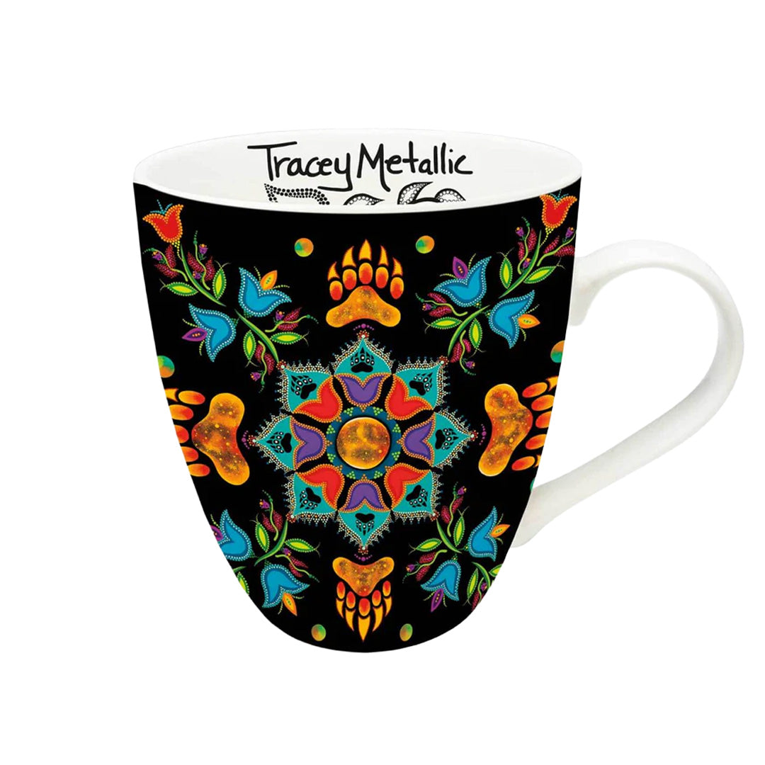 Mug with colorful mandala design on a black background, featuring the brand 'Tracey Metallic'.