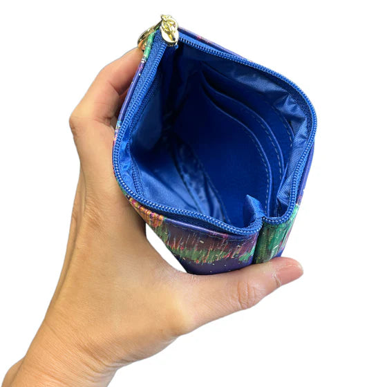 Hand holding a small pouch with a colorful design on a white background