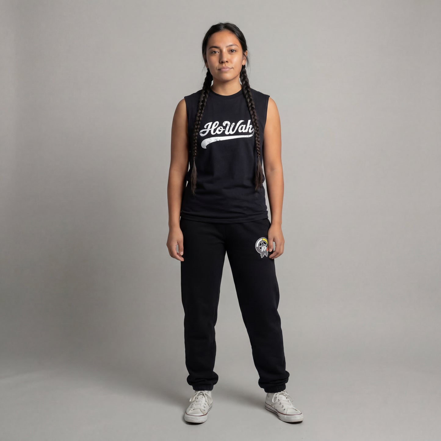 Person wearing a black sleeveless shirt with 'HoWah' text and black pants on a gray background