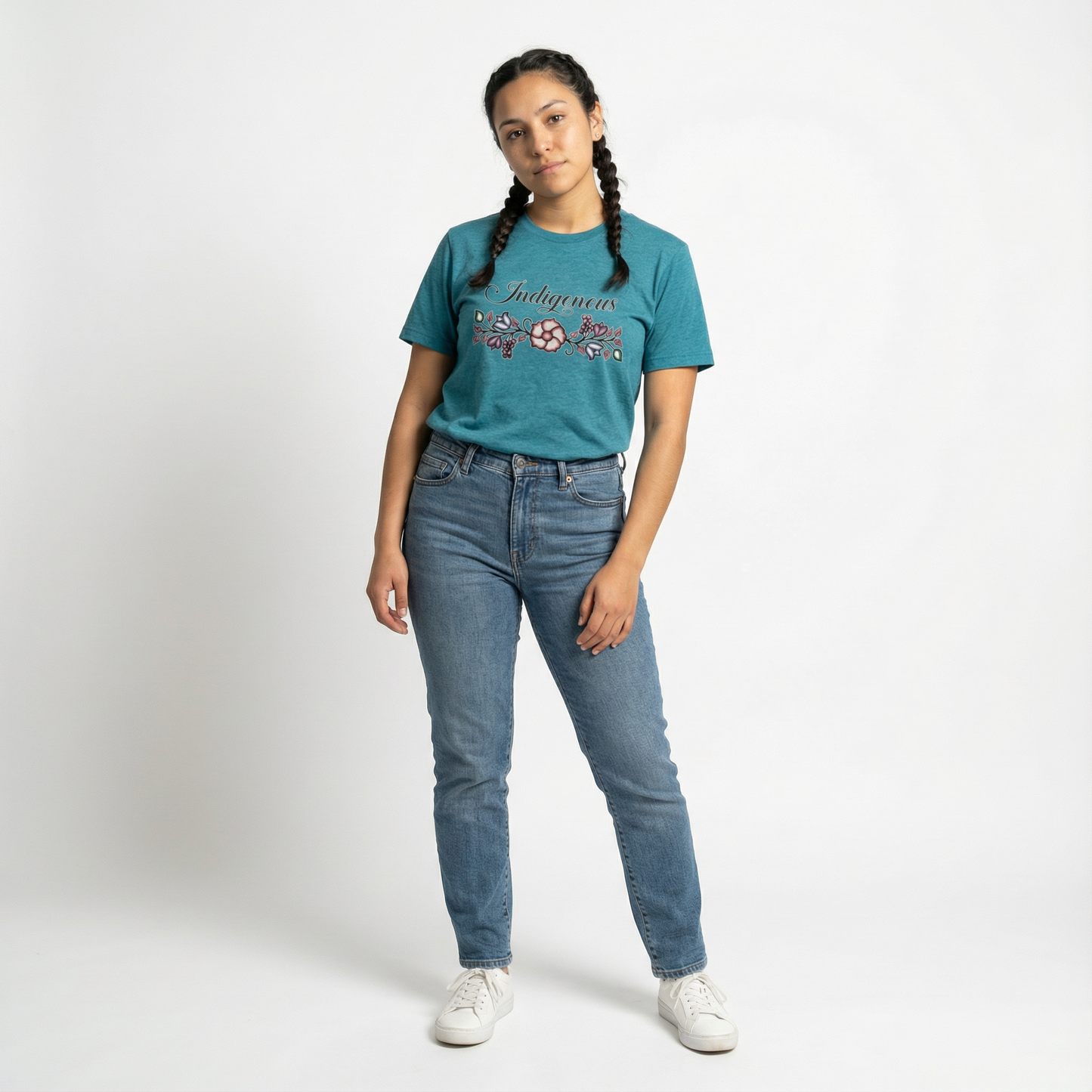 Indigenous Floral Tee worn by a model with braids, styled with blue jeans in a bright studio.
