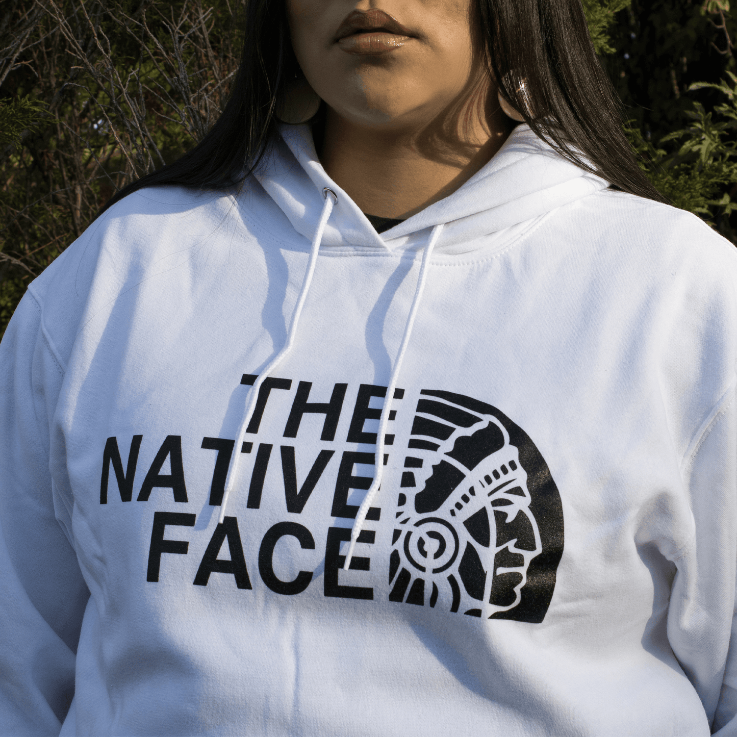 Native Face Hoodie featuring Indigenous design with oversized graphic on a white pullover.