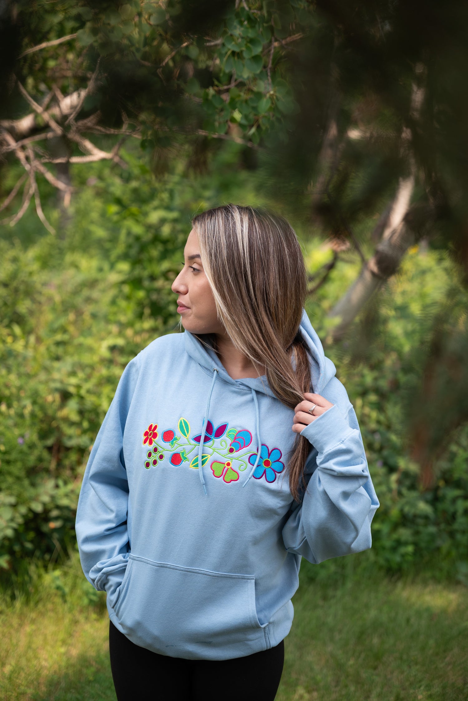 Woman wearing blue hoodie on green background