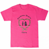 A bright pink short-sleeve t-shirt with a graphic on the front. The graphic features a braided heart outline with two small figures holding hands, the text 'Kindness Starts' above, and 'Here' below.