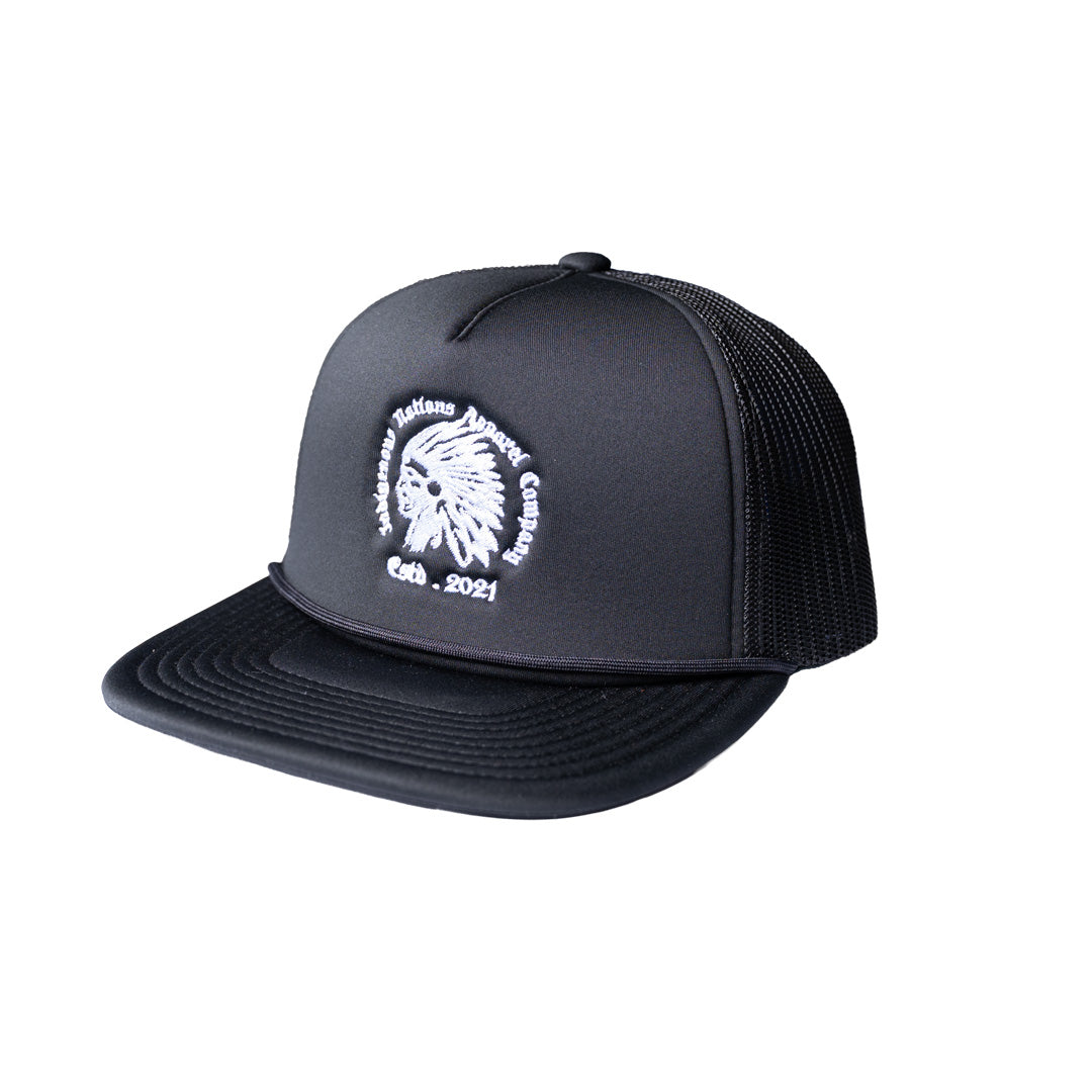 A black trucker hat with a white embroidered logo of a Native American profile and the text 'Indigenous Nations Apparel Company estd. 2021' on the front panel, set against a plain white background.