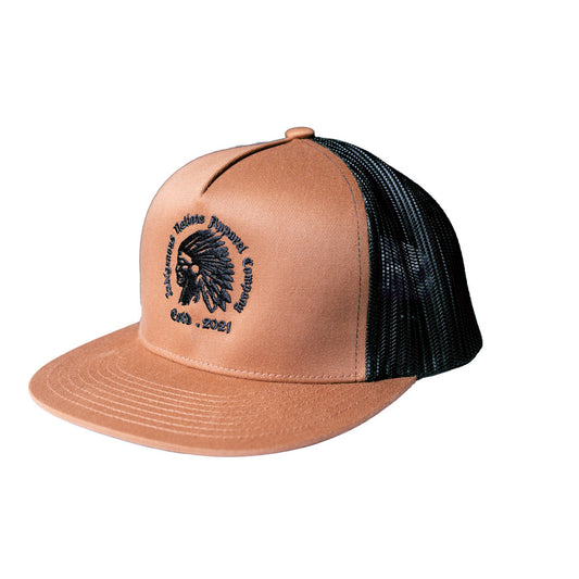 A structured trucker-style cap, black mesh back panels, and a black embroidered circular logo featuring a Native American headdress and the text 'Indigenous Nations Apparel Company' and 'Est. 2021'.