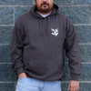 A person wearing a gray hoodie with a small white cedar leaf design on the chest.