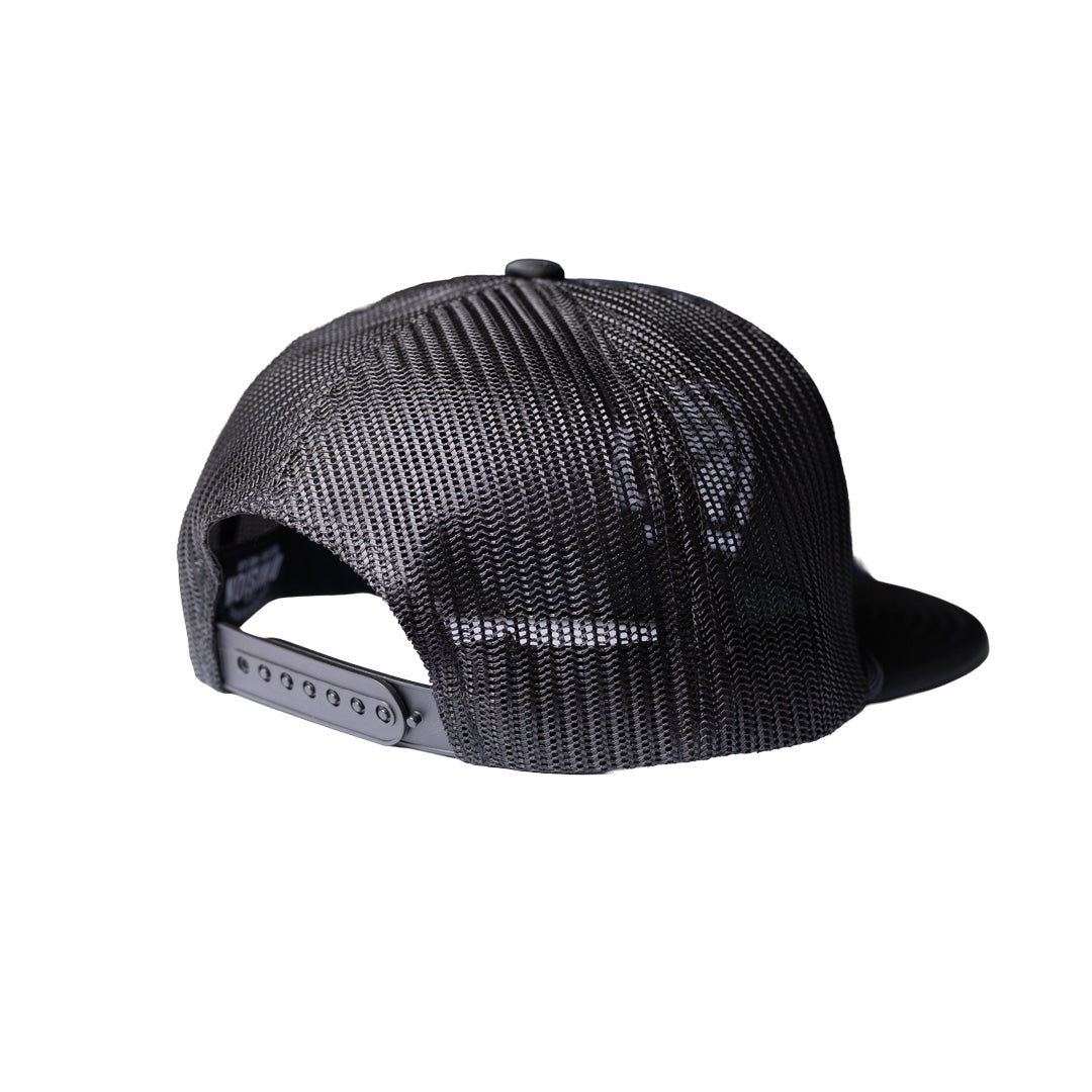 Black trucker-style snapback cap shown from the back, featuring a textured mesh back and a flat brim, on a solid white background.