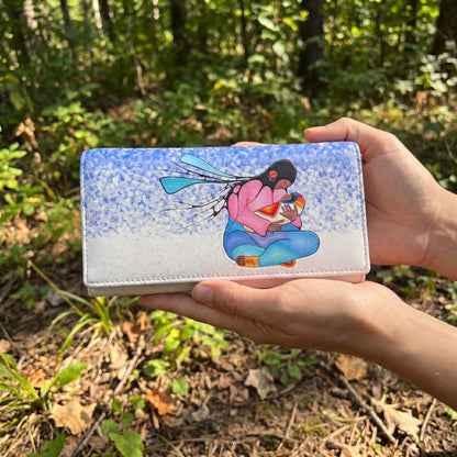 Hand holding a wallet with a cartoon character design against a forest background