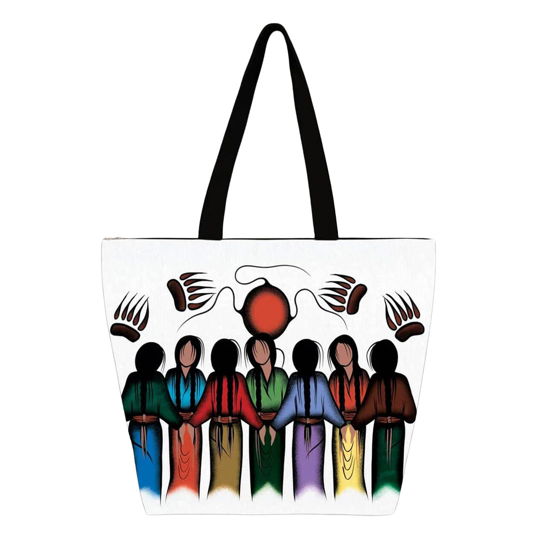 Tote bag with artistic design of people holding hands around a sun, on a white background.