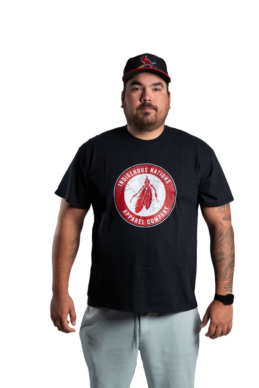 Man wearing a black t-shirt with a red logo and a cap on a white background
