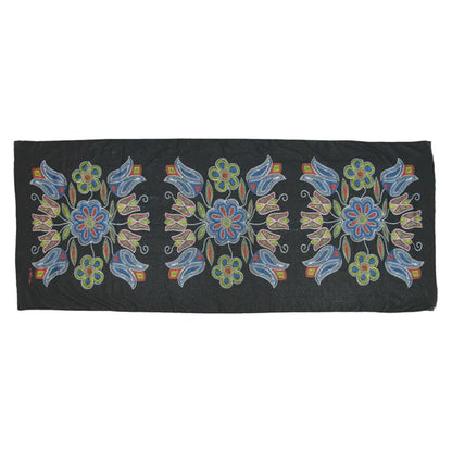 Black fabric with colorful floral embroidery on a white background