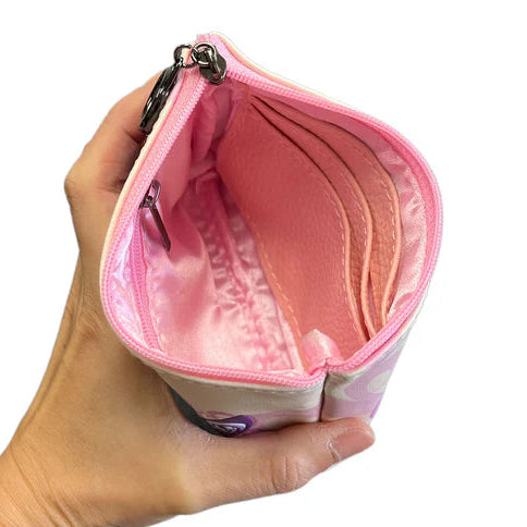 Hand holding a pink coin purse with a white background