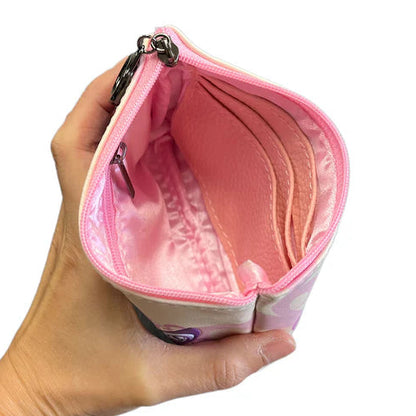 Hand holding a pink coin purse with a white background