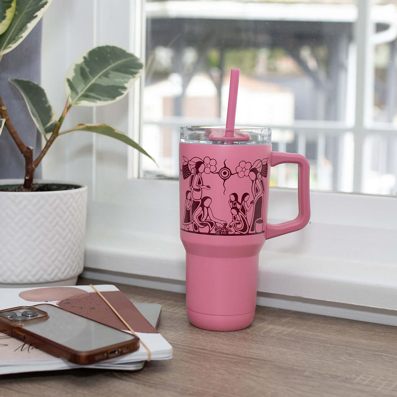 Heart Berry Gatherers insulated tumbler with pink Indigenous design on the table 