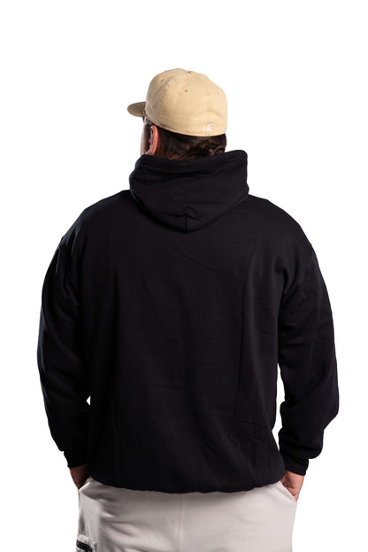 Person wearing a black hoodie and beige cap from behind on a white background