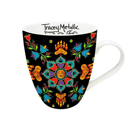 Mug with colorful mandala design on a black background, featuring the brand 'Tracey Metallic'.