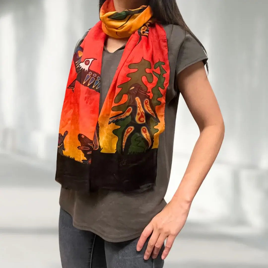 Seven Grandfather Teachings Eco-Scarf featuring vibrant colors and Anishinaabe artwork modeled by a woman.