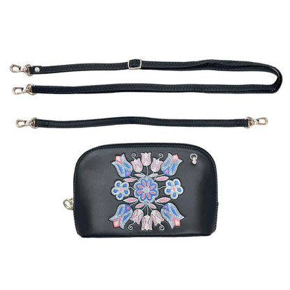 Black handbag with floral embroidery and detachable strap on a white background