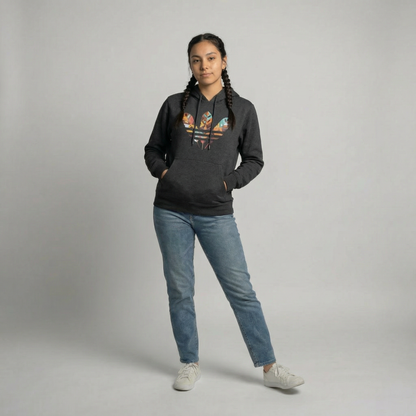 Person wearing a heather grey hoodie with colorful graphics and blue jeans on a gray background