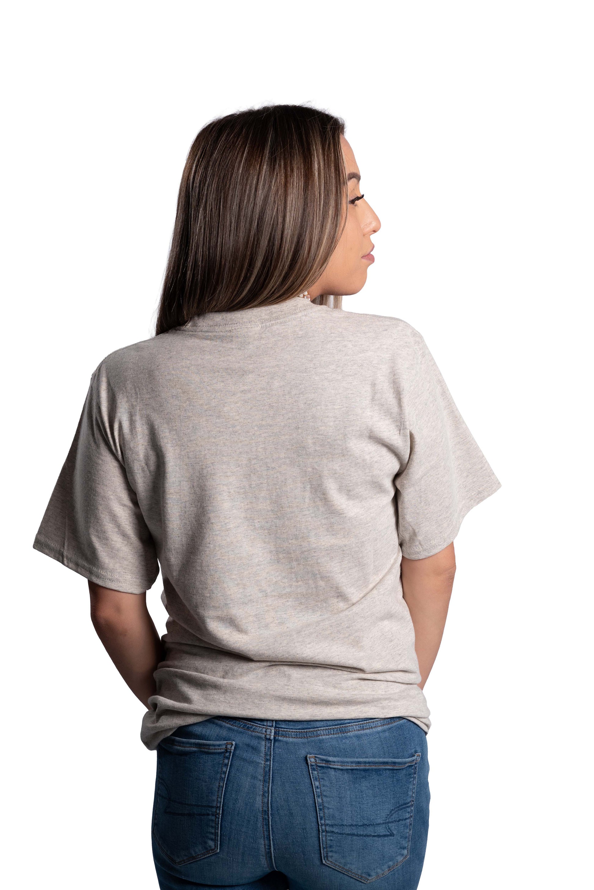 Person wearing a plain gray t-shirt and blue jeans on a white background