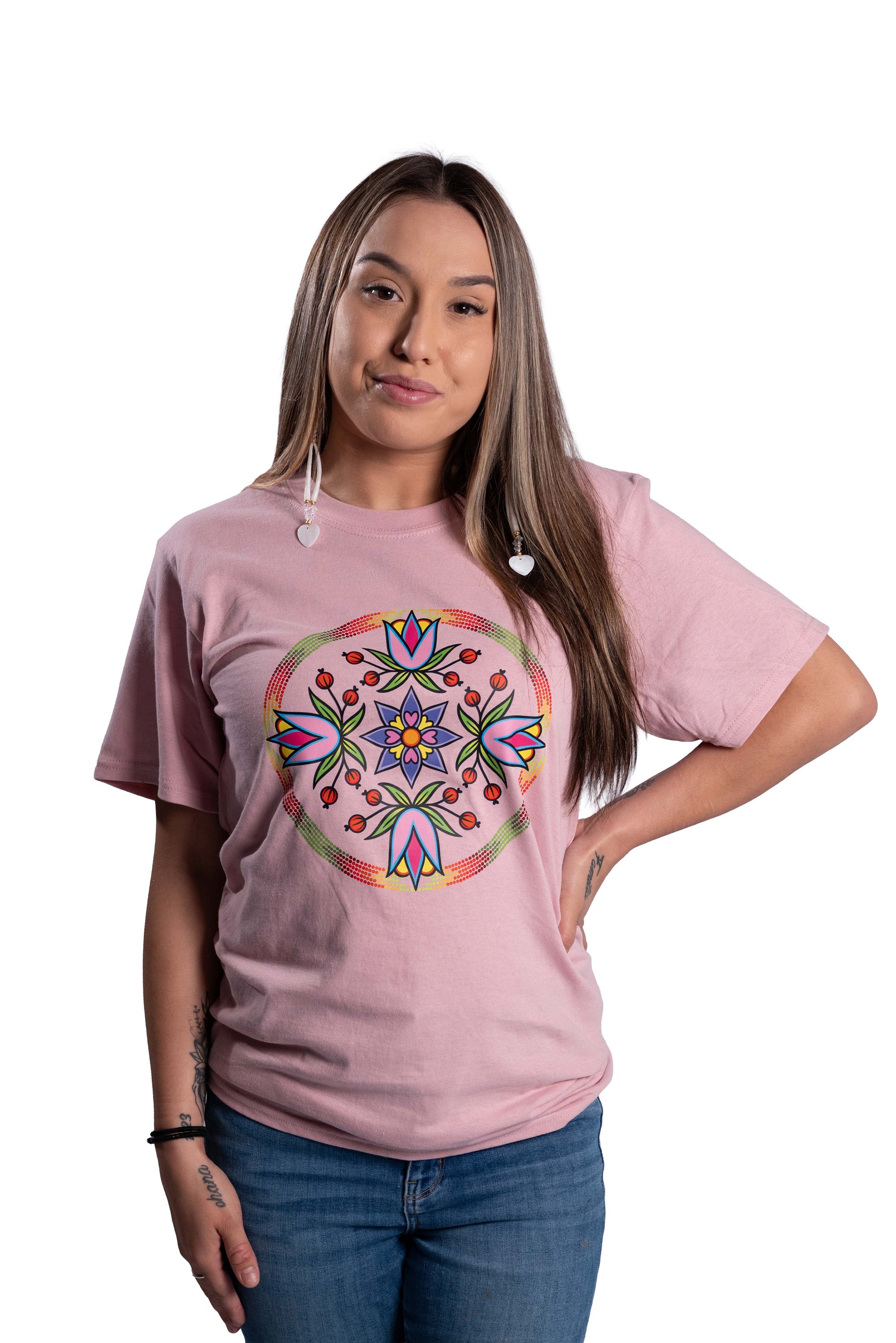 Woman wearing a pink t-shirt with a colorful mandala design on a white background