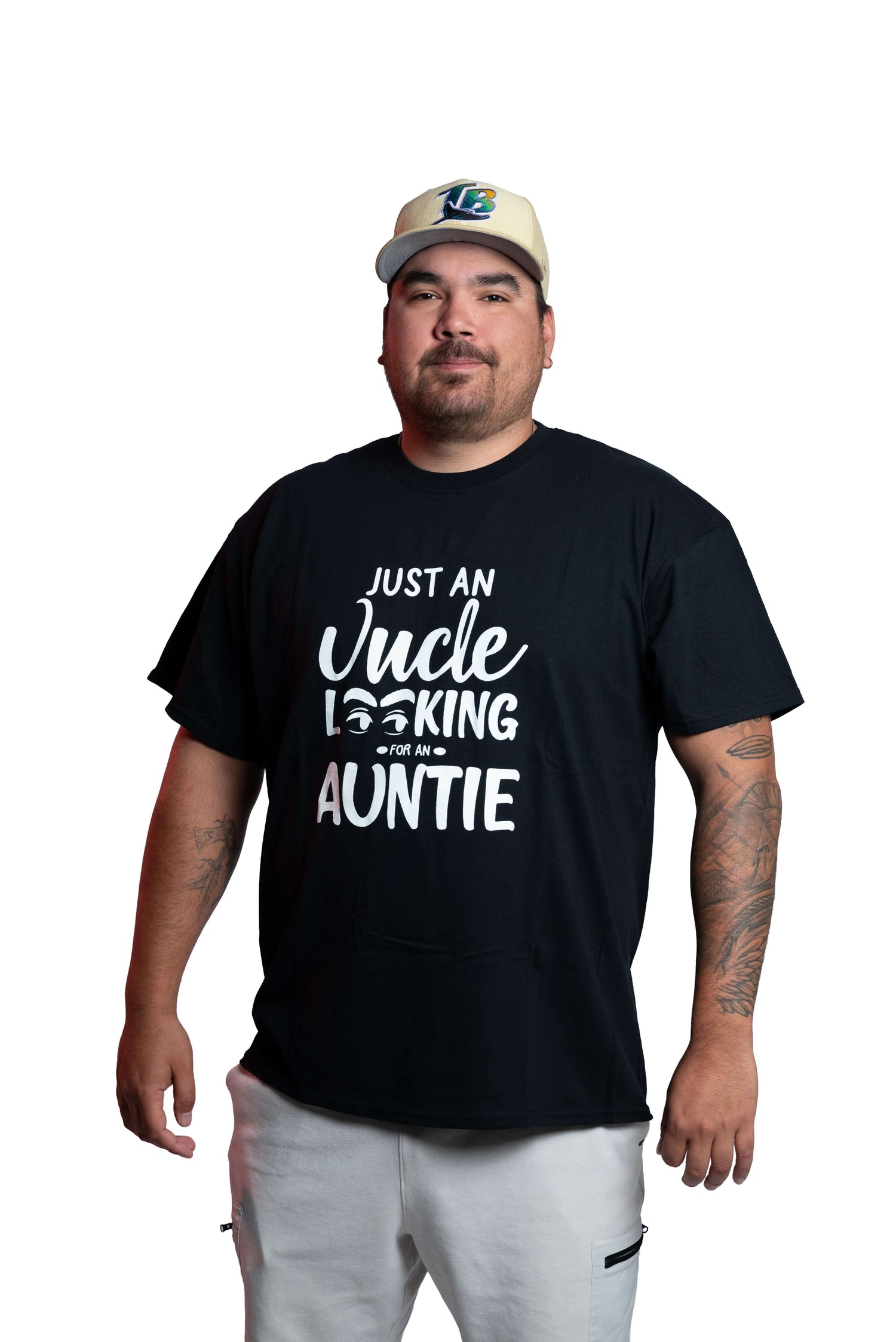 Man wearing a black “Uncle Looking for Auntie” graphic tee and cap front view