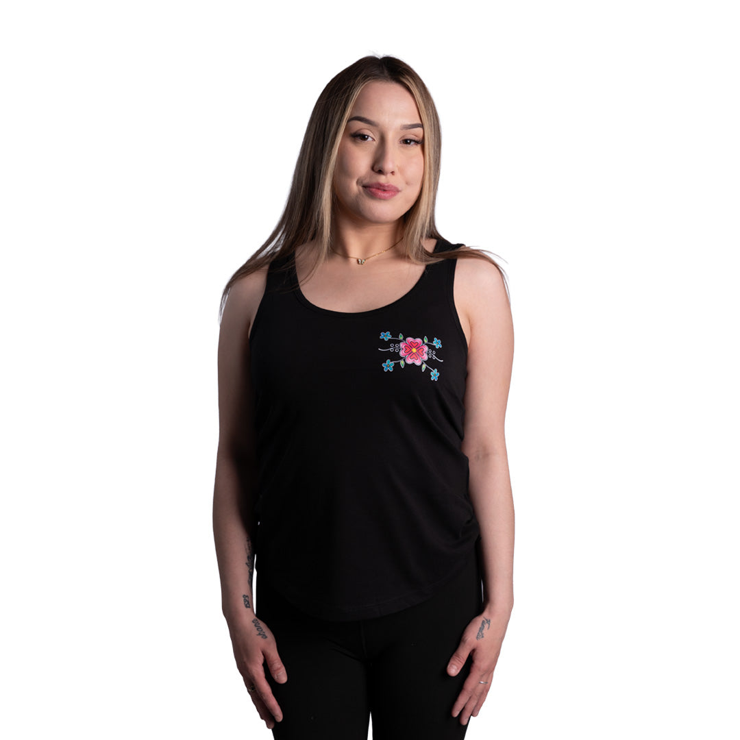 Woman wearing a black tank top with a floral design on a white background