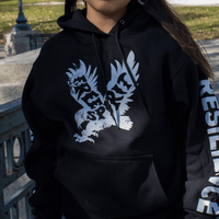 Model wearing a black Free Spirit Hoodie featuring bold eagle graphics and a message of resilience.