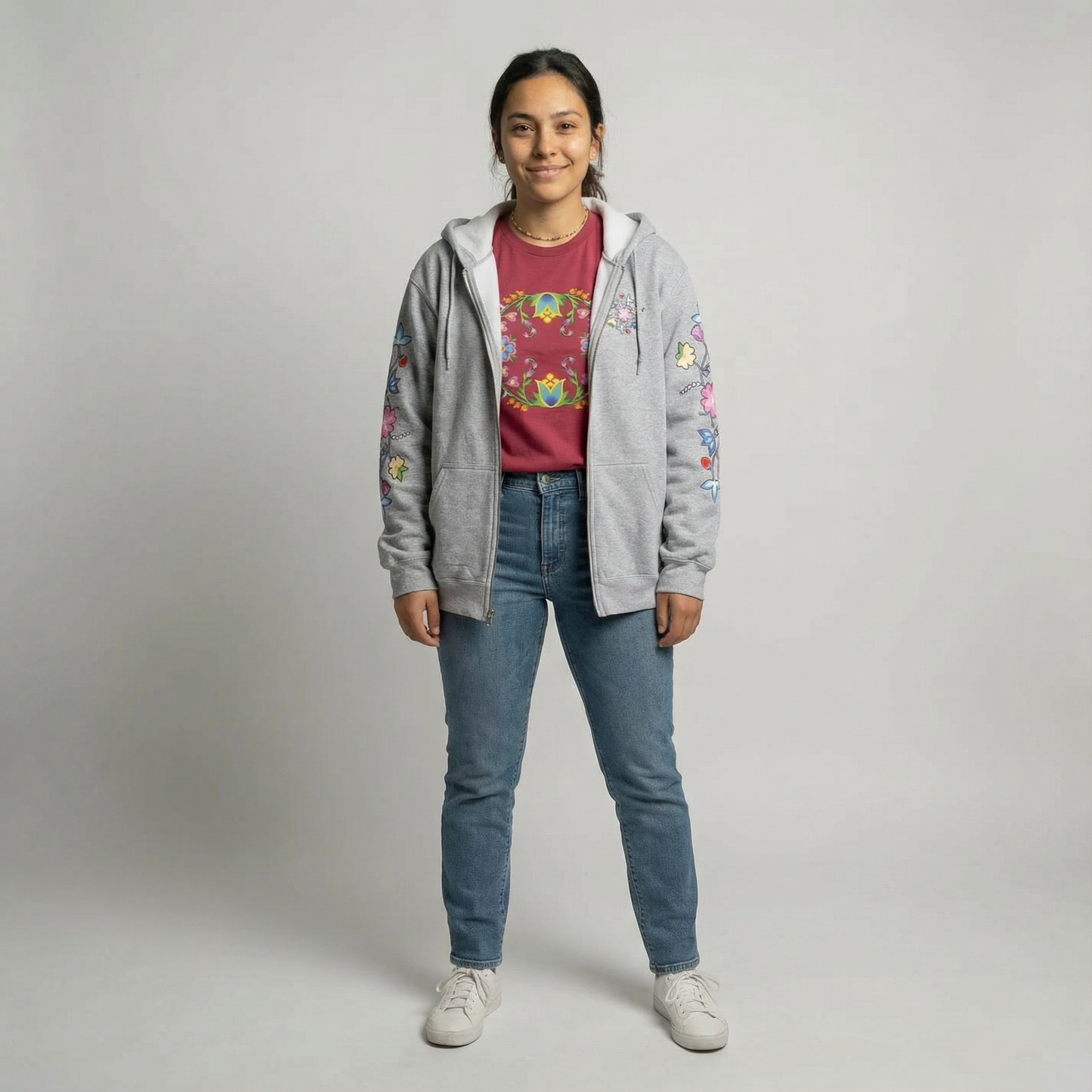 Model wearing McPhee Floral Zip-Up Hoodie with colorful floral design, styled with a graphic t-shirt and jeans.