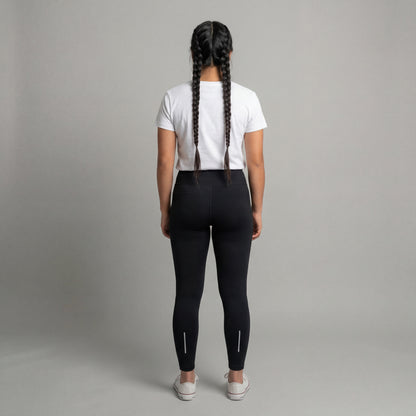 Person wearing black leggings and a white t-shirt on a gray background