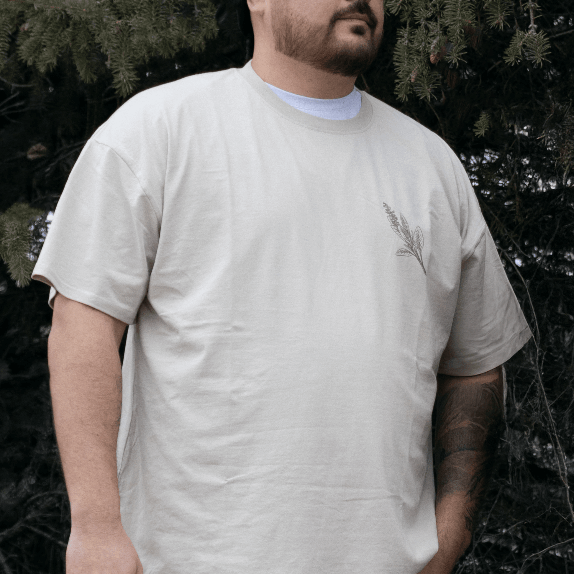 Person wearing Sage Medicine Tee in beige Indigenous streetwear graphic shirt