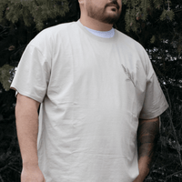 Person wearing Sage Medicine Tee in beige Indigenous streetwear graphic shirt