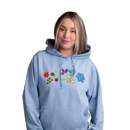 A woman modeling a light blue pullover hoodie with a colorful embroidered floral design on the chest, set against a plain white background.