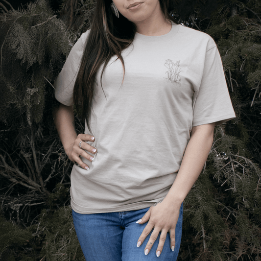 Person wearing Sweetgrass Medicine Tee in beige Indigenous streetwear with cultural design